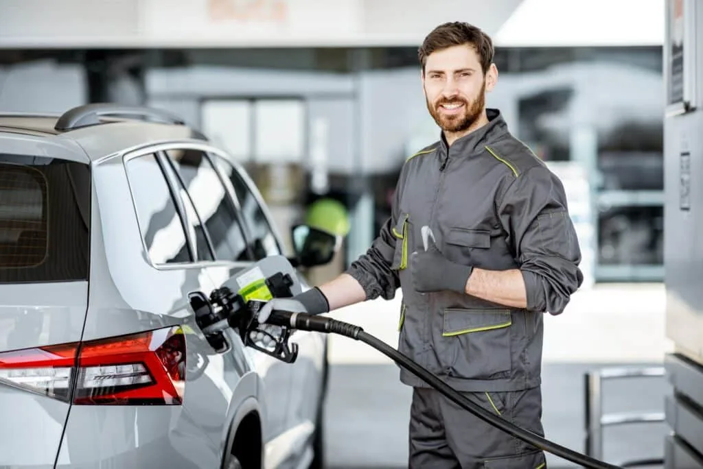 Tankwart betankt ein Auto an der Tankstelle